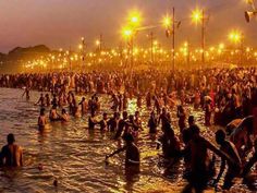 many people are standing in the water at night