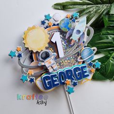 a close up of a cake topper with the word george on it and stars