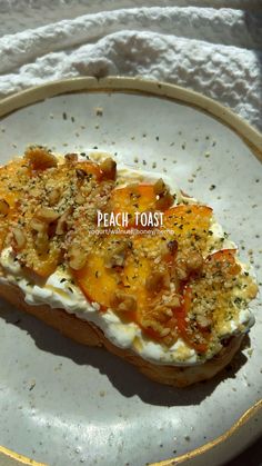 a piece of bread with cheese and toppings on it sitting on a white plate