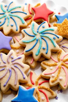 decorated sugar cookies on a plate with sprinkles and stars in the background