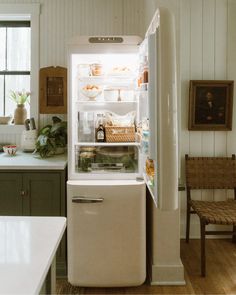 an open refrigerator in a kitchen next to a table