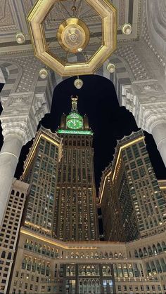 the clock is on top of the building in the middle of the city at night