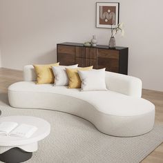 a large white couch sitting on top of a living room floor next to a table