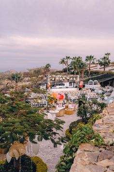 an aerial view of a beach resort with palm trees and umbrellas on the tables