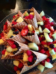 fruit and waffle cones are arranged on a glass platter, ready to be eaten