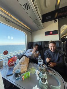 two people sitting at a table on a train