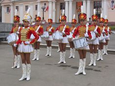 a group of people that are standing in the street with some drums and drumsticks