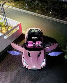 a pink car parked in front of a building