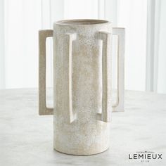 a white vase sitting on top of a table