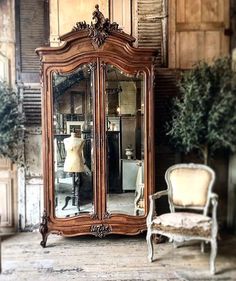 an antique armoire and chair in a room