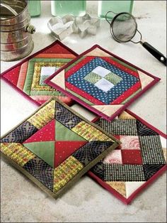 three quilted coasters sitting on top of a table