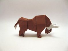 an origami bull is standing on its hind legs and it's tail curled up