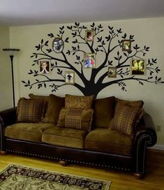 a living room with a couch and tree on the wall