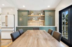 a large wooden table sitting in the middle of a kitchen