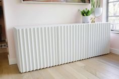 a white radiator sitting on top of a hard wood floor