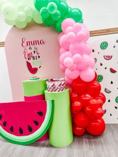 there are balloons, watermelon and other items on the floor next to each other