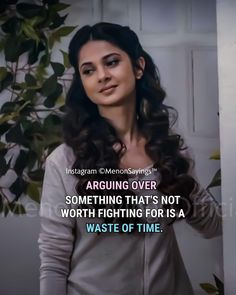 a woman standing in front of a plant with an inspirational quote on the back ground