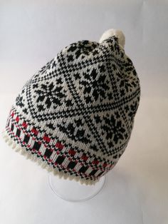 a white and black hat on top of a glass stand