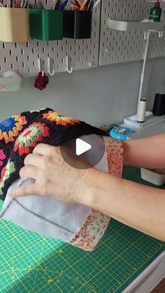 a woman is sewing on a piece of fabric