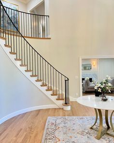 a living room filled with furniture and a spiral stair case next to a white table