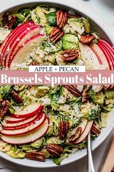 an apple pecan brussels sprouts salad in a white bowl with silverware