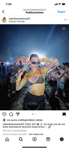 a woman with sunglasses on standing in front of a crowd