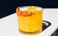 a yellow drink sitting on top of a white table