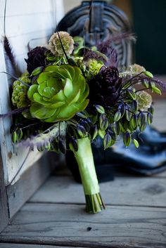 a bridal bouquet with green and purple flowers