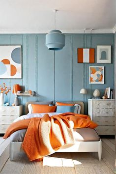 a bedroom with blue walls and orange accents