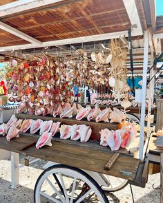 an outdoor market with lots of different types of meats on the table and hanging from the ceiling