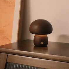 a mushroom lamp sitting on top of a wooden dresser