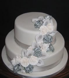 a white wedding cake with silver flowers on top