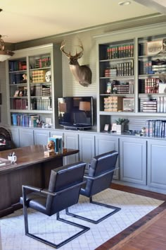 a living room filled with furniture and a book shelf covered in deer's head mounted on the wall