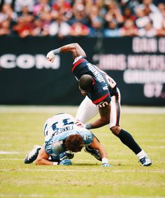 an autographed football player is trying to get past another player on the field