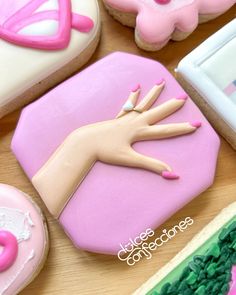 decorated cookies with pink and white icing on a table