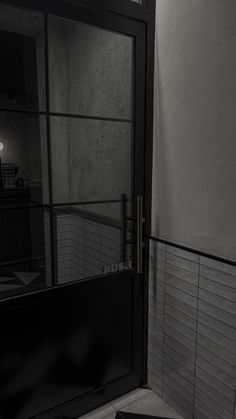 a black and white photo of a door in a room with tile flooring on the walls