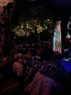 a dark room filled with lots of clutter and blankets on top of a bed