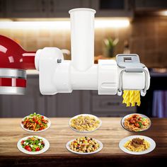 a kitchen appliance that is on top of a table with many plates of food