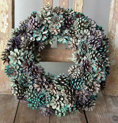 a wreath made out of pine cones sitting on top of a wooden table