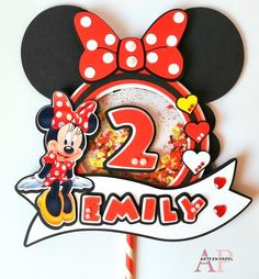 a mickey mouse cake topper with the number two on it and a minnie mouse holding a donut