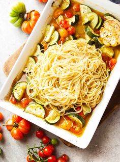 a white dish filled with pasta and vegetables