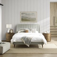 a bedroom with white walls and wooden furniture, including a large bed in the center