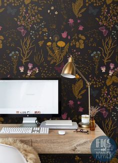 a desktop computer sitting on top of a wooden desk next to a wallpaper covered in flowers