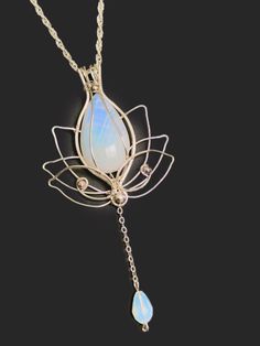 Silver Lotus pendant necklace with Moonstone, Wire Wrapped rainbow moonstone pendant Material: silver plated wire Details:  Color:blue, silver This pendant will charm you with its original silver swirl pattern on this magical moonstone! This design was specially created for a white rainbow moonstone, Czech crystals and wire wrap with silver plated wires. This wonderful moonstone has a magical rainbow sheen in the sunlight! More neklace in my shop you can find here:  https://etsy.me/2Rkuo6O SHIPPING Comes with tracking Your jewelry will be beautifully packaged in a protective gift box  Please understand that I am not responsible for delays due to Customs or the Postal Service NECKLACE: *This pendant comes with a complimentary necklace, so it is ready to wear and enjoy right out of the box! Silver Wire Wrapped Moonstone Jewelry, Silver Wire Wrapped Moonstone Necklace, Silver Moonstone Teardrop Pendant, Silver Moonstone Teardrop Pendant Jewelry, Nickel-free White Moonstone Necklace, Lotus Pendant, Magical Rainbow, Rainbow Moonstone Pendant, White Rainbow