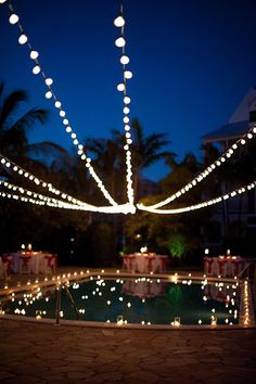 a pool covered in christmas lights at night