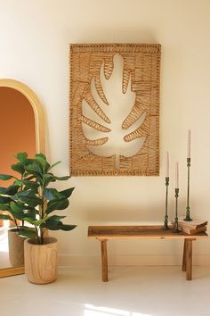 a room with a table, mirror and potted plant