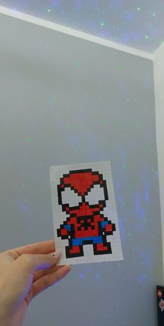 someone is holding up a sticker with an image of spider man on it