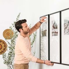 a man is pointing to pictures on the wall