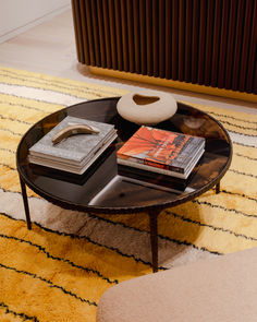 a coffee table with books on it in front of a heater and radiator