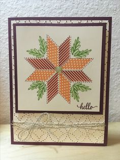 a card with an orange and green flower on the front that says hello in white lettering